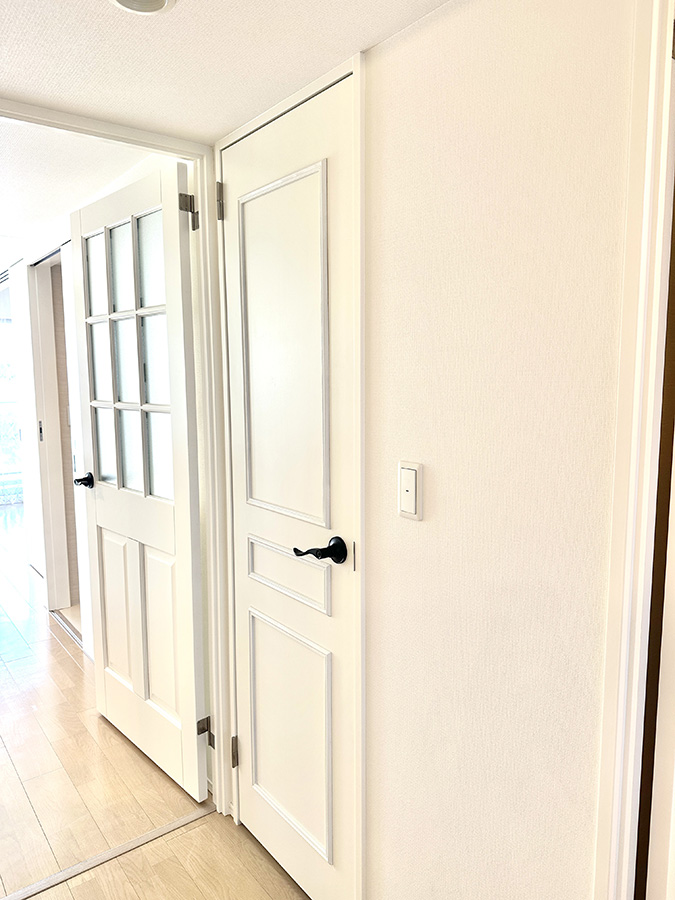 パネルデザインを抑えた白い室内ドアのディテール。主張を控え、空間の輪郭を整えるための建具設計。