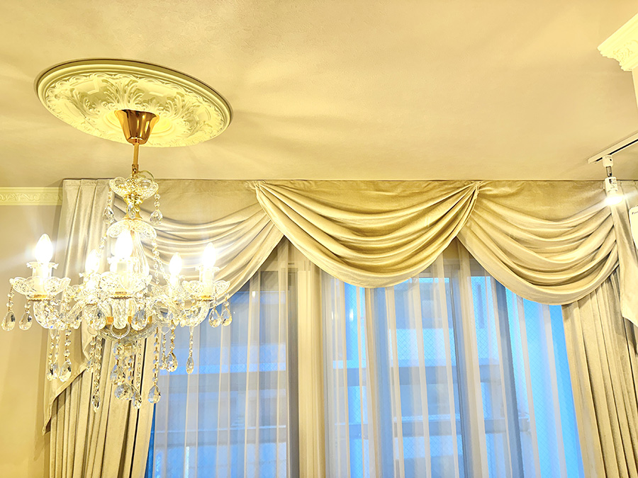 ロココ調シャンデリアと天井メダリオン、エレガントなカーテンが調和するクラシックな空間